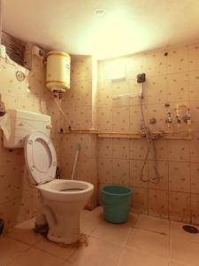 un baño con inodoro y ducha en The Pink Chapter Hostel, Jaipur, en Jaipur