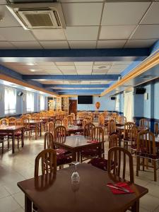 a dining room with tables and chairs and a tv at Pensión Agarimo in Trapagaran