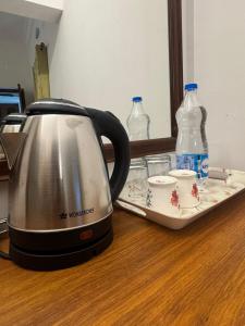 a tea kettle on a counter with two bottles of water at Villa de Compass Homestay Auroville in Kottakupam