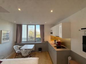 a small kitchen with a table and a desk at Residence Issy in Issy-les-Moulineaux