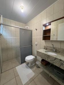 a bathroom with a toilet and a sink at Casa de 03 dormitórios no centro de Bombinhas in Bombinhas +29 photos