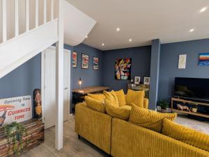 un salon avec un canapé jaune et une table dans l'établissement Heart of Hove Modern House, à Brighton et Hove