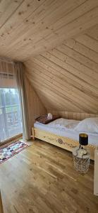 una cama en una habitación con techo de madera en Bachledowy Wierch, en Czerwienne