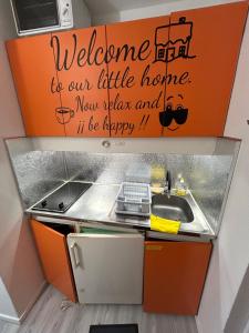 a kitchen with a sink and a sign on the wall at Studio Les Cimes au pied des pistes in La Mongie +2 photos