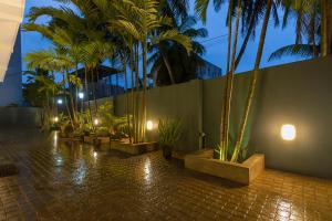 un cortile con palme e un muro con luci di Kuvin Villa a Hikkaduwa