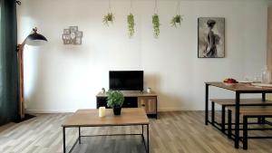 ein Wohnzimmer mit 2 Tischen und einem TV in der Unterkunft L'Eure Au Soleil, avec balcon et Wifi in Évreux