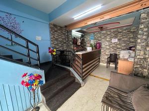 TyāmagondalにあるHotel O Kalpatharu Boarding and Lodgingの階段と花が飾られたカウンターのある部屋 +5枚の写真