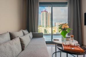 カサブランカにあるCasablanca City Center Maarifのリビングルーム(ソファ、窓付きテーブル付)