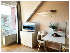 a room with a desk with a television on a dresser at Maritimes Appartement in der Lagunenstadt Ueckermünde in Ueckermünde