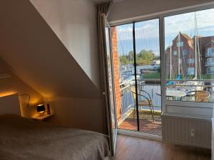 a bedroom with a large window with a view of a marina at Maritimes Appartement in der Lagunenstadt Ueckermünde in Ueckermünde