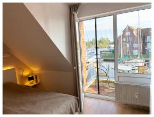 a bedroom with a bed and a large window at Maritimes Appartement in der Lagunenstadt Ueckermünde in Ueckermünde
