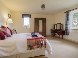 a bedroom with a bed and a desk in it at Upper Pandy Farm in Welshpool