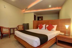 RājpurにあるHotel O namaste doonのベッドルーム1室(大型ベッド1台、赤い枕付)