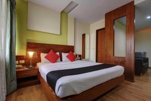RājpurにあるHotel O namaste doonのベッドルーム1室(大型ベッド1台、赤い枕付) +2枚の写真