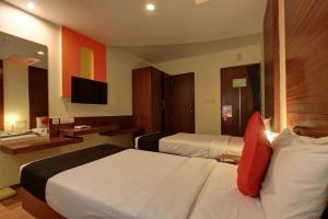 RājpurにあるHotel O namaste doonのベッド2台とテレビがあるホテルの部屋