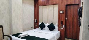 a bedroom with a bed with a phone on it at Hotel O HOTE V-SQUARE in Bijnaur