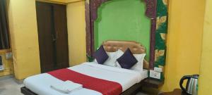 a bedroom with a bed with a padded head board at Hotel O Kumar's Amantran Lodging in Manor