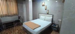 a bedroom with a white bed in a room at Hotel O Kumar's Amantran Lodging in Manor