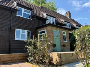 una casa nera con una porta verde di Spacious Forest Row Home by Ashdown Trails a Forest Row