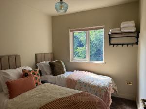 una camera da letto con due letti e una finestra di Spacious Forest Row Home by Ashdown Trails a Forest Row