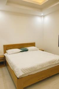a bed with white sheets and pillows in a room at Relax Homestay Phú Yên in Tuy Hoa