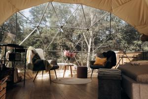 a room with two chairs and a large glass wall at River Camp in Lembuži