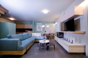 ハニア・タウンにあるVilla Casa Di Christinaのリビングルーム(青いソファ、テレビ付)