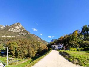 a dirt road with a house in the mountains at Agriturismo Il Contadino Simo - Dolomites Farmhouse in Mis