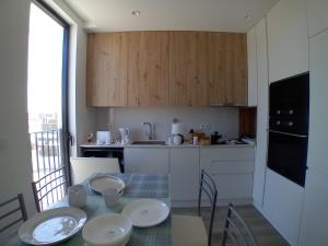 a kitchen with a table with plates on top of it at VAGUEIRA Sol in Vagos