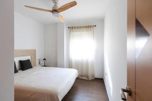 una camera da letto con un letto e un ventilatore a soffitto di house villa Salobreña a Salobreña