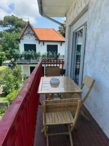 a wooden table and chairs on a balcony at T2, 50 m beach, balcony with sea view in La Teste-de-Buch +15 photos