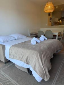 a bedroom with a large bed with towels on it at T2, 50 m beach, balcony with sea view in La Teste-de-Buch