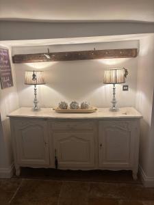 una mesa con dos lámparas encima en Cottage on high street, own parking and EV charger, en Chipping Norton