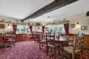a dining room with tables and chairs and windows at Greyhound Country Inn in Honiton +24 photos