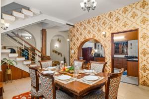 a dining room with a table and chairs at Bougain Blossom Spacez Luxury Villa with Terrace Garden in Bangalore