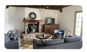 a living room with a couch and a fireplace at Maison Copé in Châtillon-sur-Broué