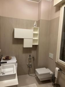 a white bathroom with a sink and a toilet at Holiday Home Parma in Parma