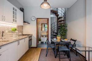 a kitchen with a table and chairs and a spiral staircase at AC House in Porto