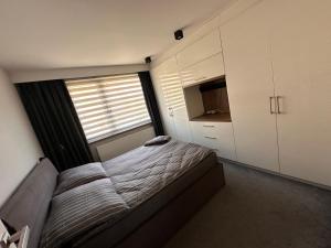 Un dormitorio pequeño con una cama y una ventana. en Komfort MazuryBase, en Ostróda
