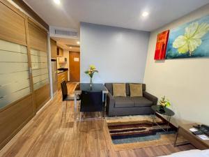 a living room with a couch and a table at AMIS By Sima Thani in Ban Lak Roi