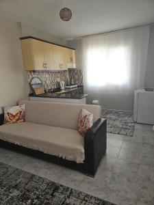 a living room with a couch and a kitchen at NEŞELİ APART BAHÇE CAFE in Seferihisar