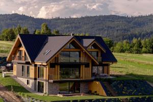 a house with a metal roof on a hill at Villa Revere - luksus w sercu Podhala in Nowy Targ +155 photos