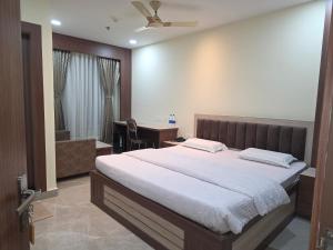 Un dormitorio con una cama grande y un baño. en Corporate Habitat, en Bhubaneshwar