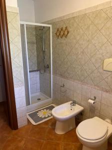 een badkamer met een douche, een toilet en een wastafel bij La Luna Sarda, Bosa in Bosa Marina +15 foto's