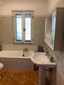 een badkamer met een wastafel en een ligbad bij La Luna Sarda, Bosa in Bosa Marina