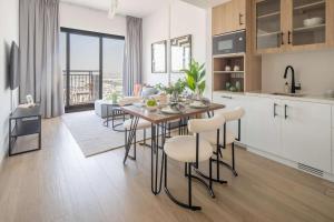 une cuisine et un salon avec une table et des chaises dans l'établissement Frank Porter - Liva, Townsquare, à Nadd Shubayḩ