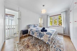 ein Schlafzimmer mit einem Bett und einem Fernseher und Fenstern in der Unterkunft Modern spacious four bedroom house in London in Hendon