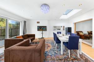 ein Wohnzimmer mit einer Couch und einem Tisch und Stühlen in der Unterkunft Modern spacious four bedroom house in London in Hendon