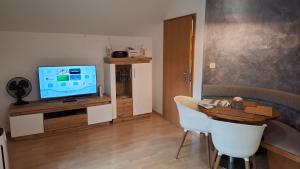 a living room with a table and a television at Ferienwohnung Wildgatter in Grafenwiesen