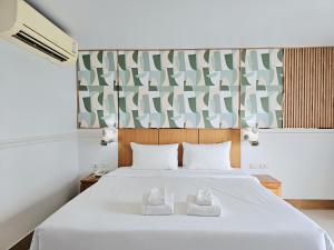 a bedroom with a white bed with two towels at Nanthana Villa in North Pattaya